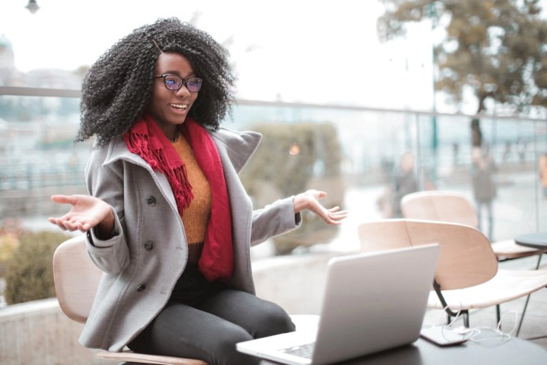 cheerful surprised woman sitting with laptop during a YouTube live stream